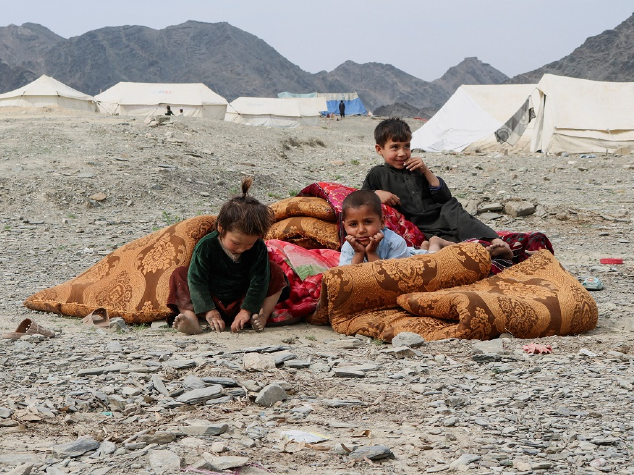 Afghan children sit outside their makeshift tent as they take refuge in Lal Pur district. Photo: Reuters