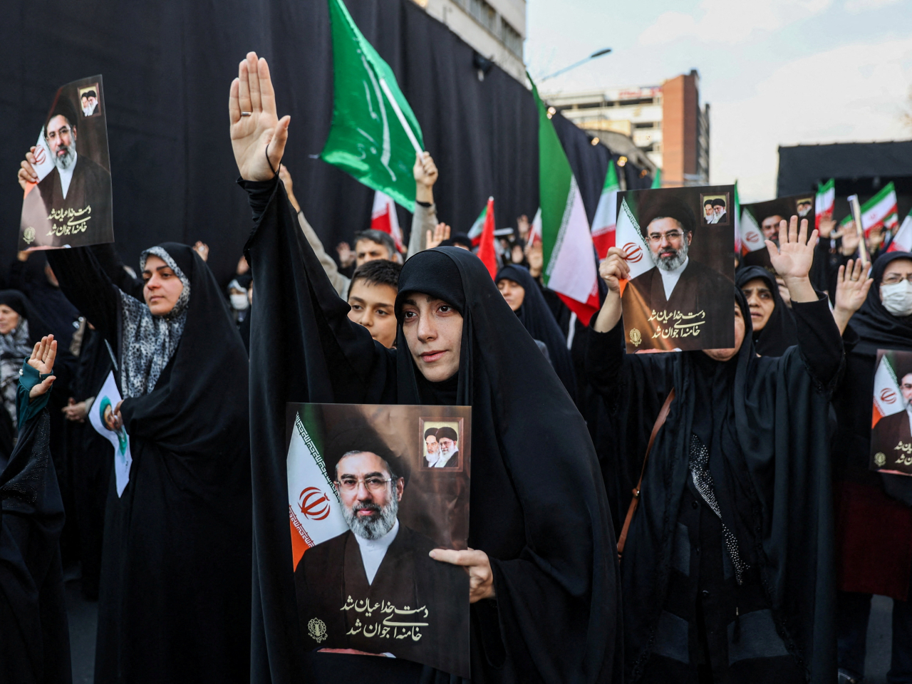 在德黑蘭革命廣場，集會人士舉起穆傑塔巴的照片並高呼他的名字。（路透社）