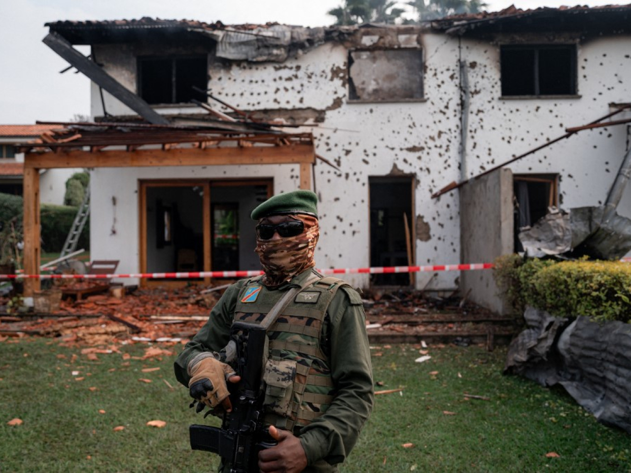 An M23 member stands guard near a private residence damaged by a drone strike in Goma. Photo: AFP