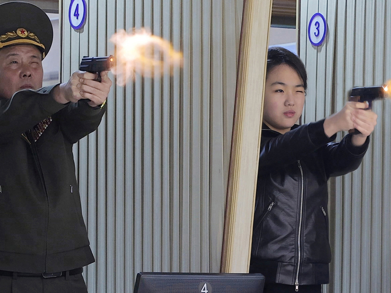 金主愛（右）試射手槍。（路透社）