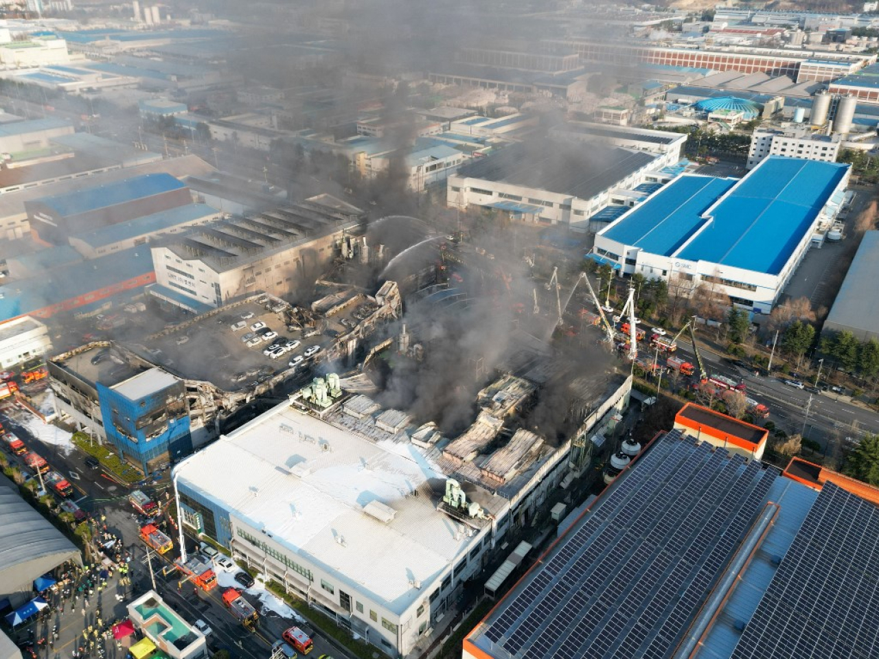 Firefighters spray water to extinguish the fire at a car parts plant in Daejeon. Photo: AFP
