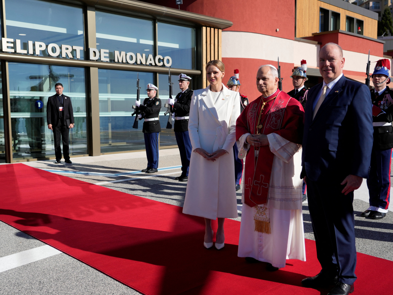 Pope Leo is flanked by Prince Albert II and Princess Charlene on arrival at the heliport in Monaco. Photo: Reuters