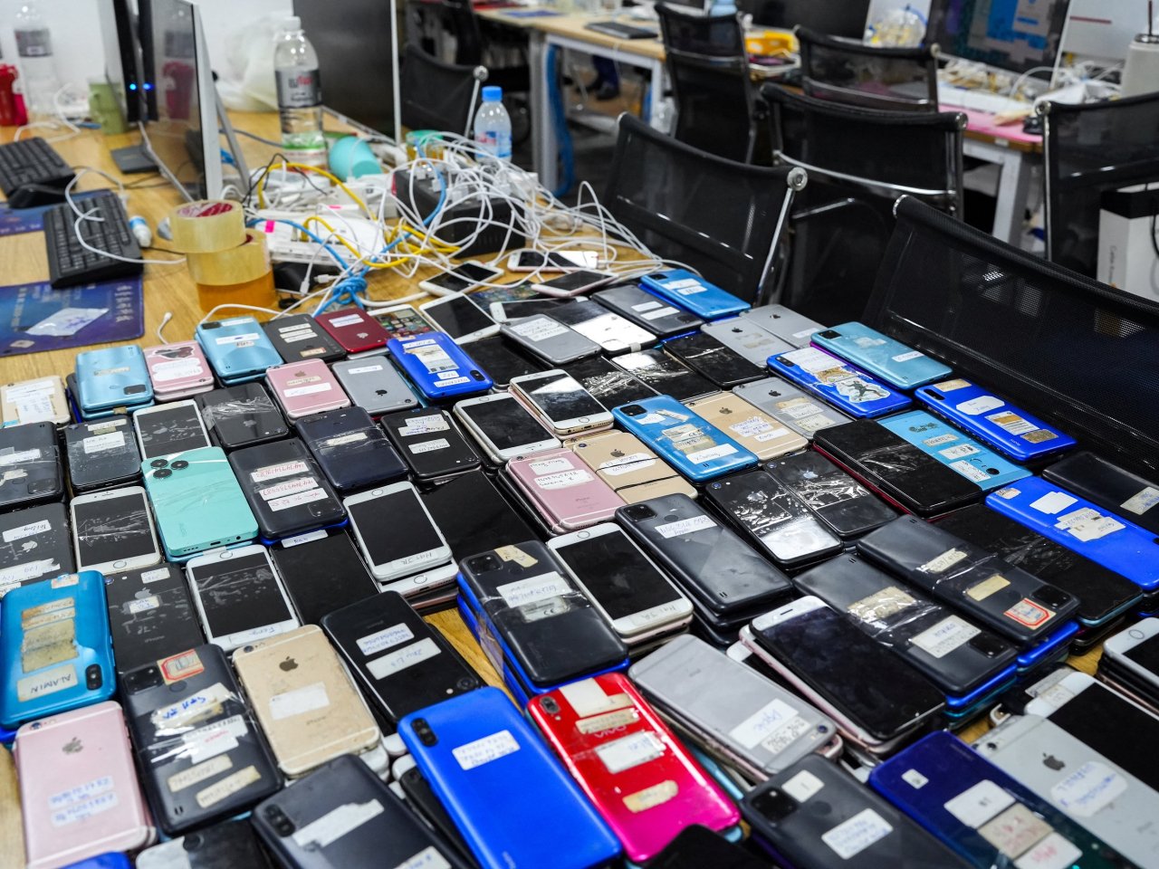 Police seize mobile phones and other items in an online scam crackdown at a hotel in Phnom Penh earlier this month. File photo: Reuters
