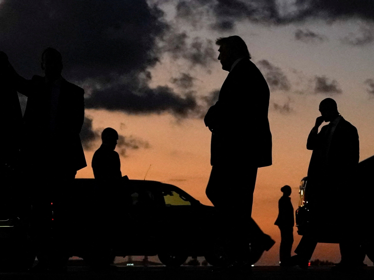 Donald Trump is silhouetted as he walks upon arrival at Palm Beach International Airport in Florida enroute to his Mar-a-Lago club. Photo: Reuters