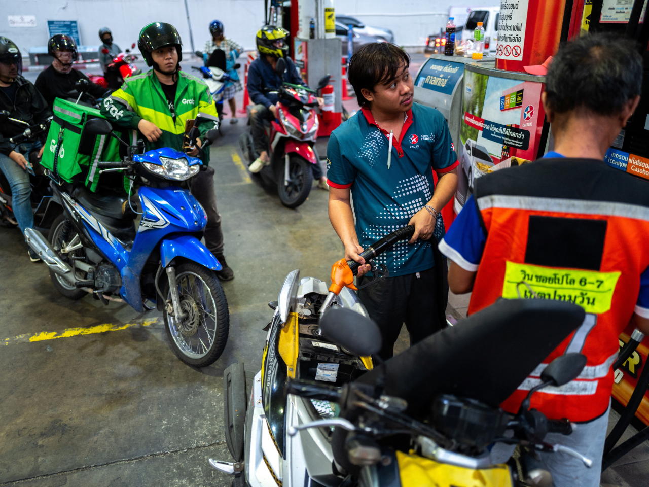 Motorcyclists queue up at a petrol station in Bangkok. File photo: Reuters