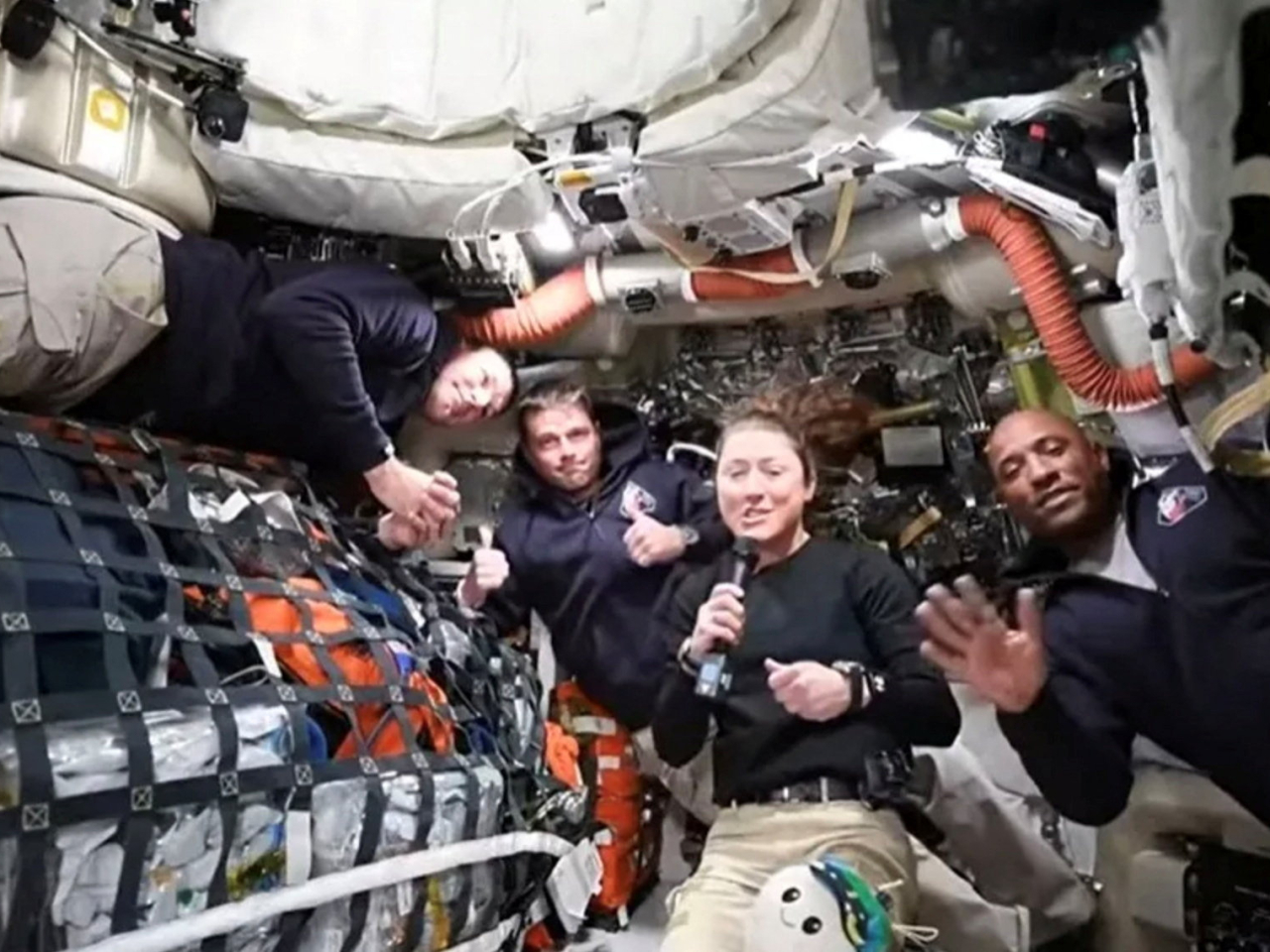 Christina Koch, flanked by, from left, Jeremy Hansen, Reid Wiseman and Victor Glover, answers a question during the mission's first downlink. Photo: Nasa handout/Reuters