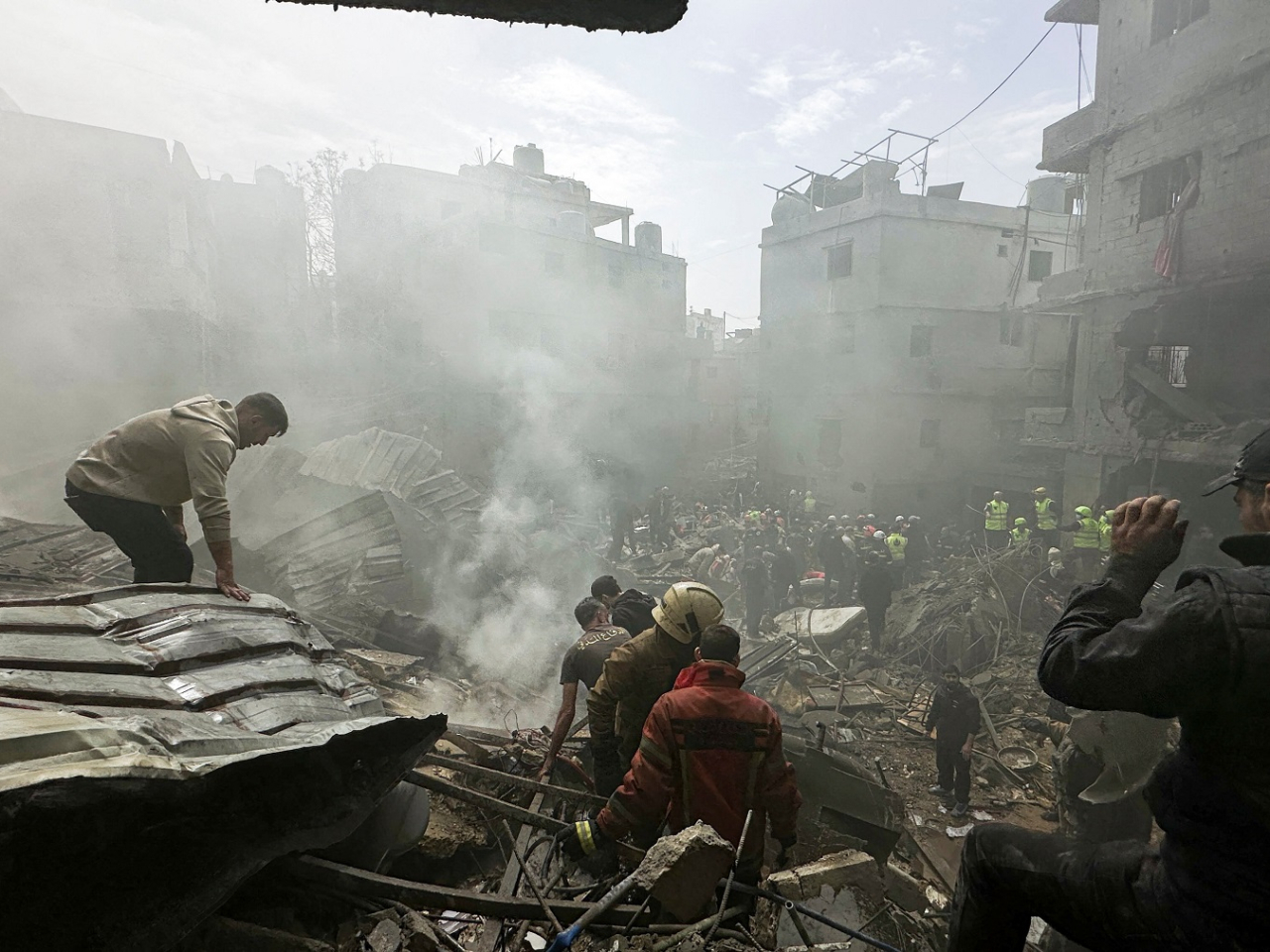 People gather as rescuers work at the site of an Israeli strike in the Jnah area in Beirut, Lebanon. Photo: Reuters