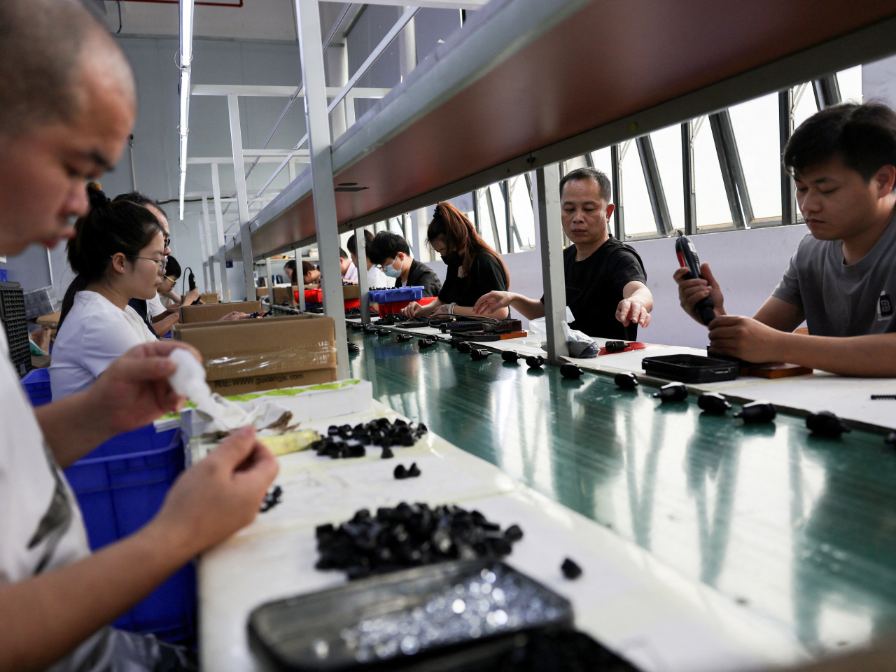 Staff assemble car smartphone holders at a factory as rising oil prices drive up plastic costs for manufacturers in Dongguan, Guangdong. File photo: Reuters