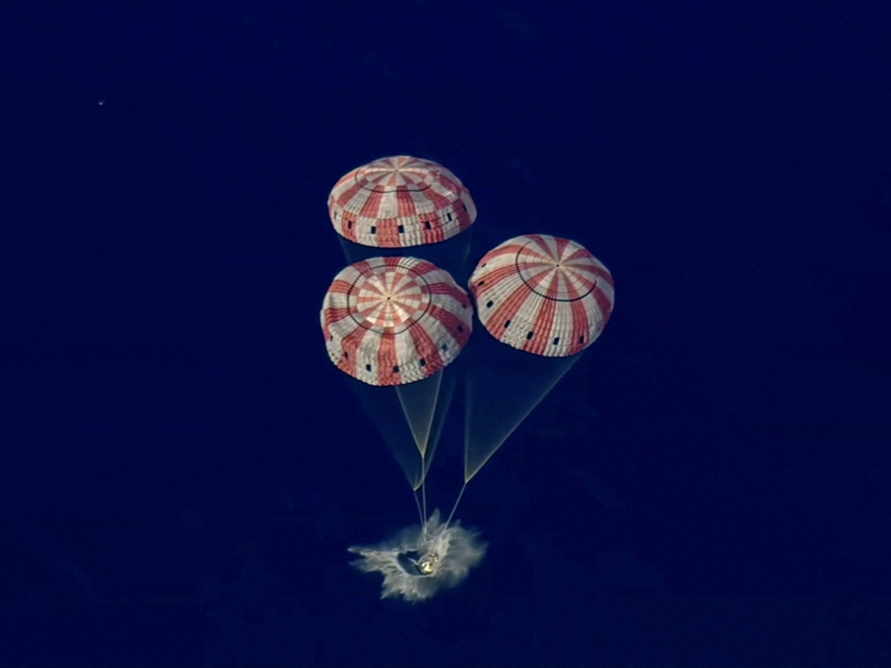 The Artemis II crew capsule splashes down in the Pacific Ocean in this screengrab from a livestream video after a flyby of the Moon. Screengrab: Nasa via Reuters