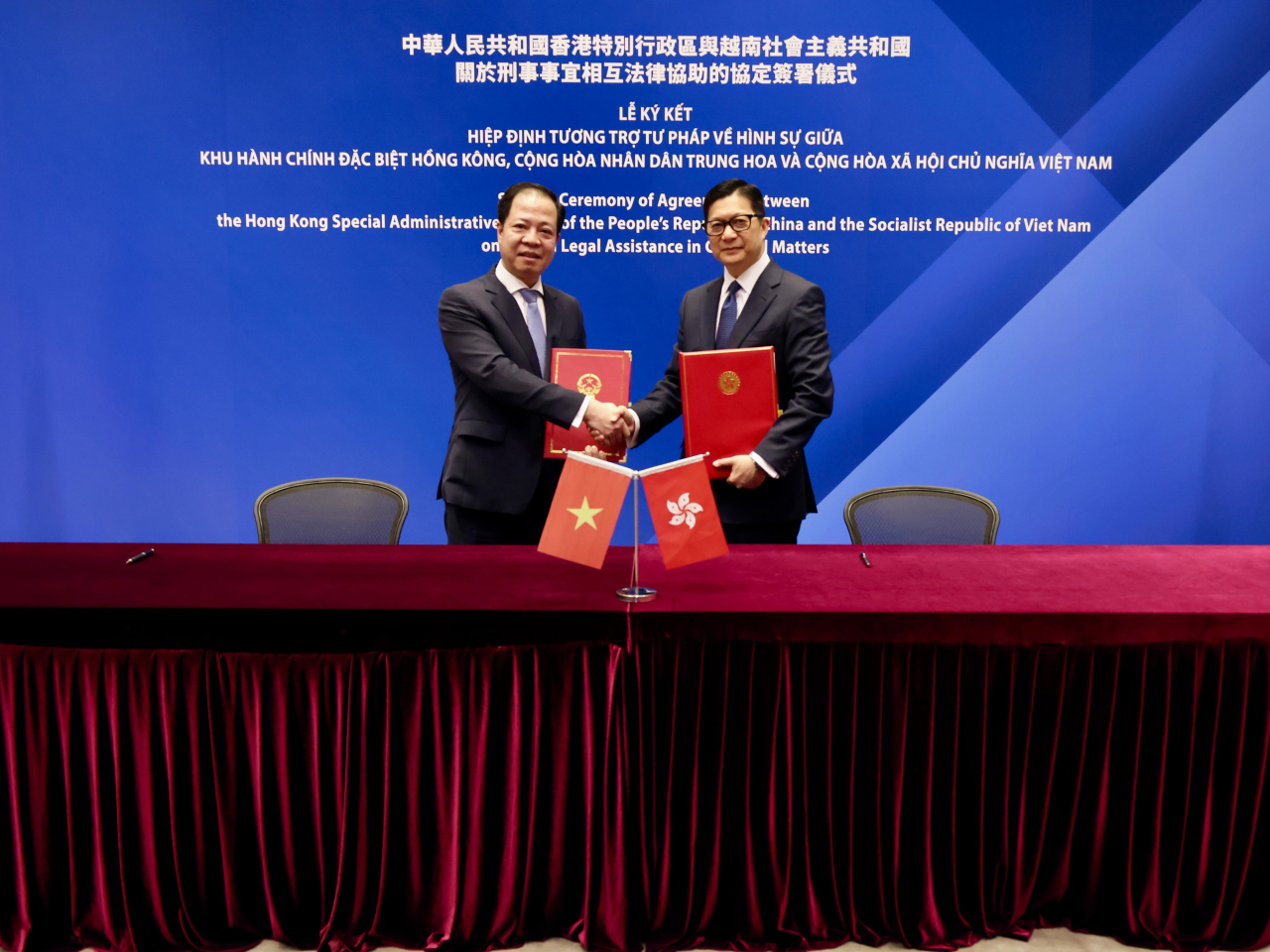 鄧炳強（右）於簽署儀式上與陳海軍（左）合照。（政府新聞處）