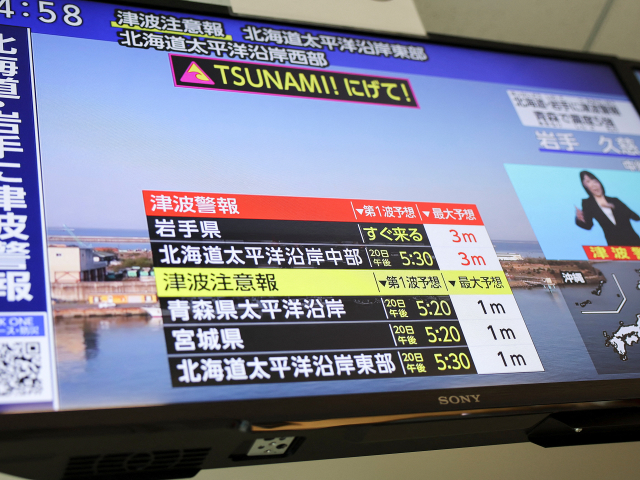A tsunami alert warning of waves of up to three metres flashes on a television news channel in Tokyo. Photo: Reuters