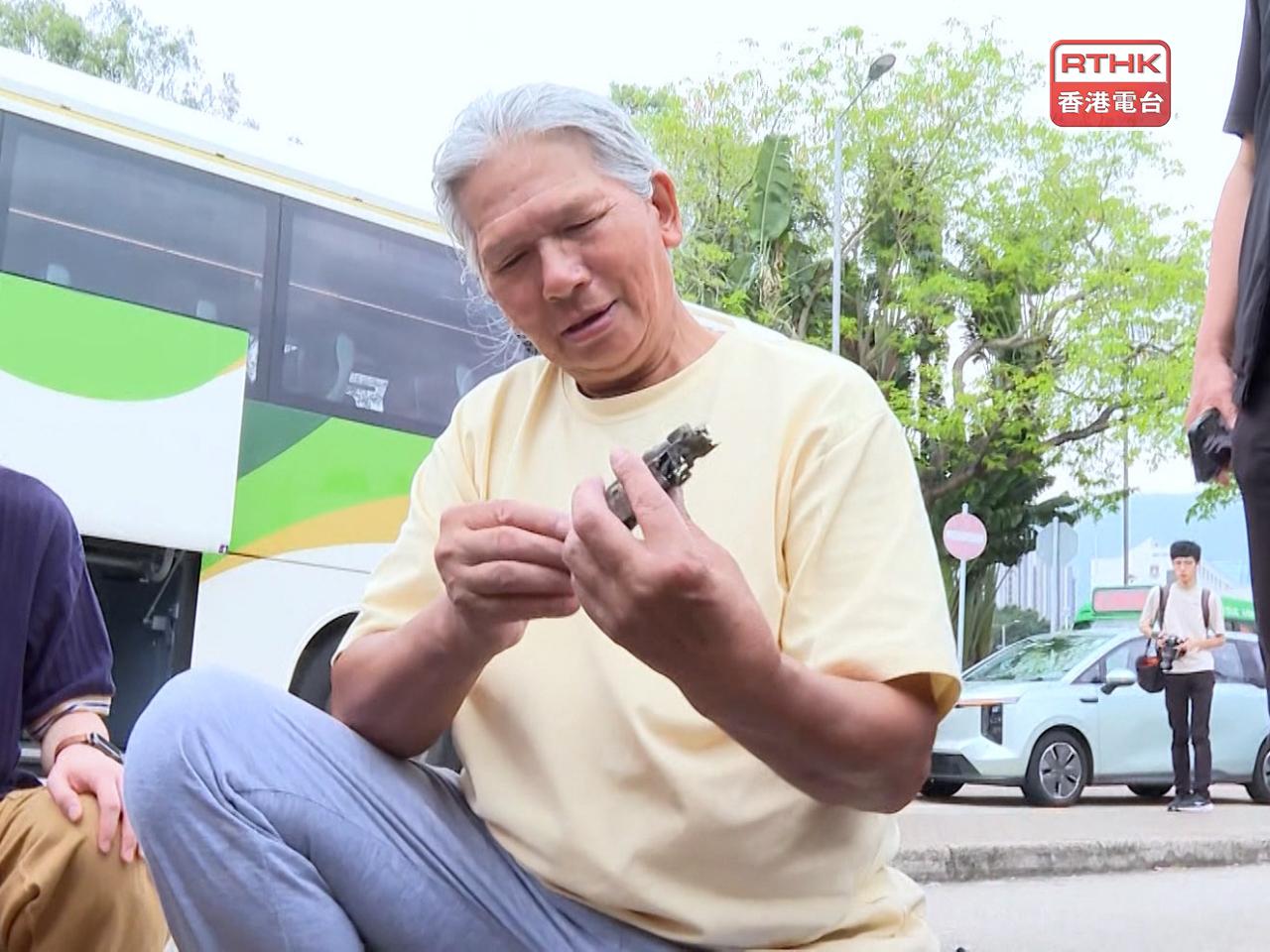 盧先生執拾了一些被火燒過的相機，表示自己很喜歡攝影，相機對他來說是別具意義。（陳頌慈攝）