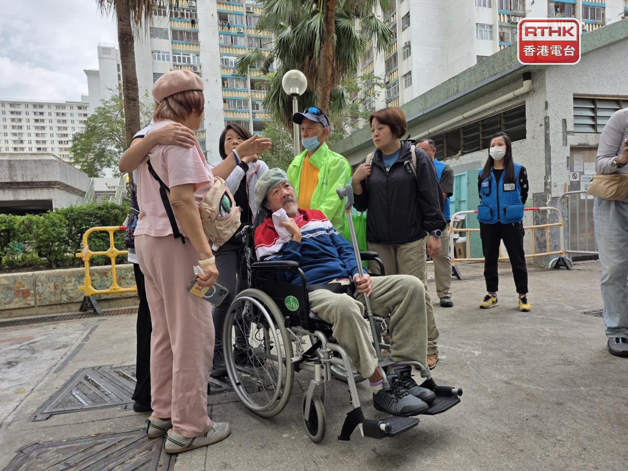 陳太與丈夫不上樓，等家人透過視像方式，拍攝家中情況，與單位道別。（陳曉慶攝）