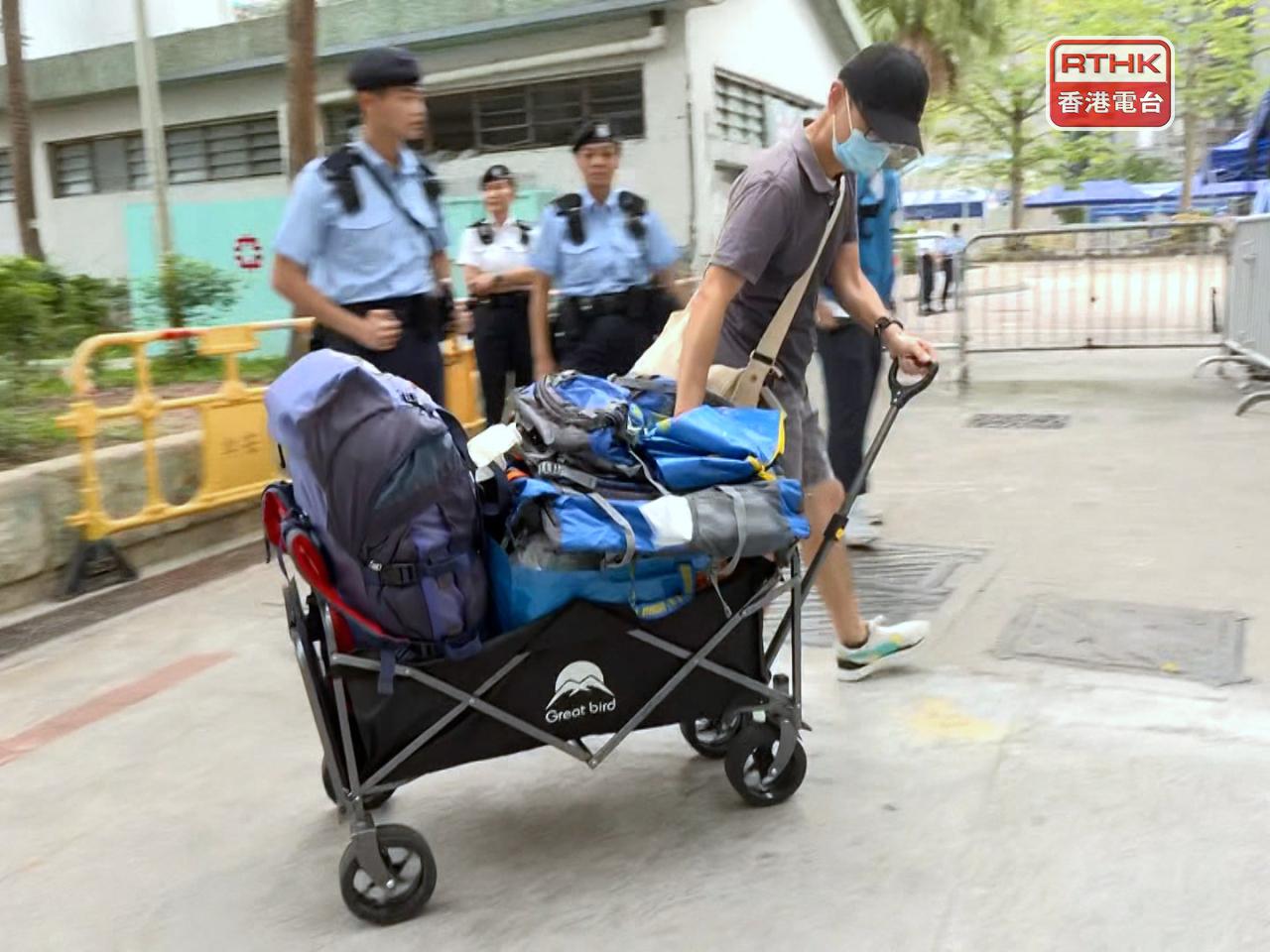 有人帶同手推車、背囊、紅白藍袋、鮮花等上樓。（梁禎祥攝）