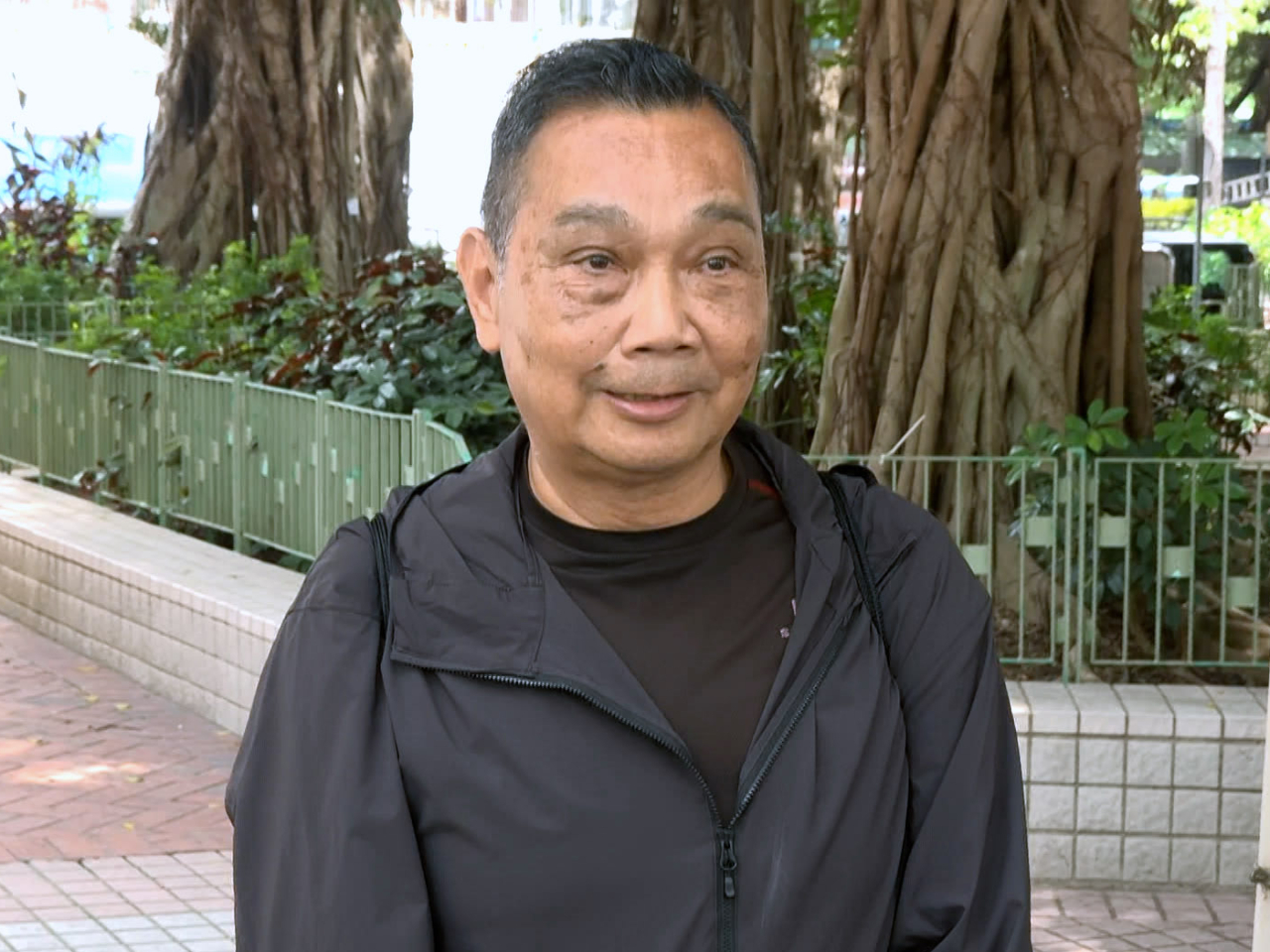 胡先生今天特意穿了逃生時所穿着的衣服重回宏福苑，但由於腳部受傷仍未完全康復，未能行上樓。（梁禎祥攝）