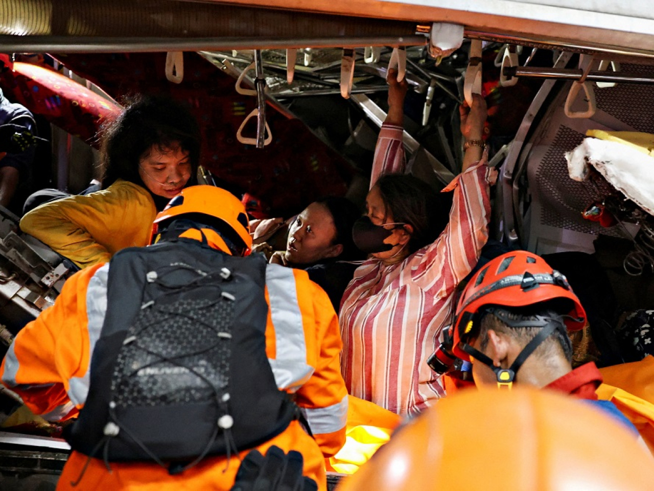 Emergency personnel rescue victims trapped in the damaged commuter train. Photo: Reuters