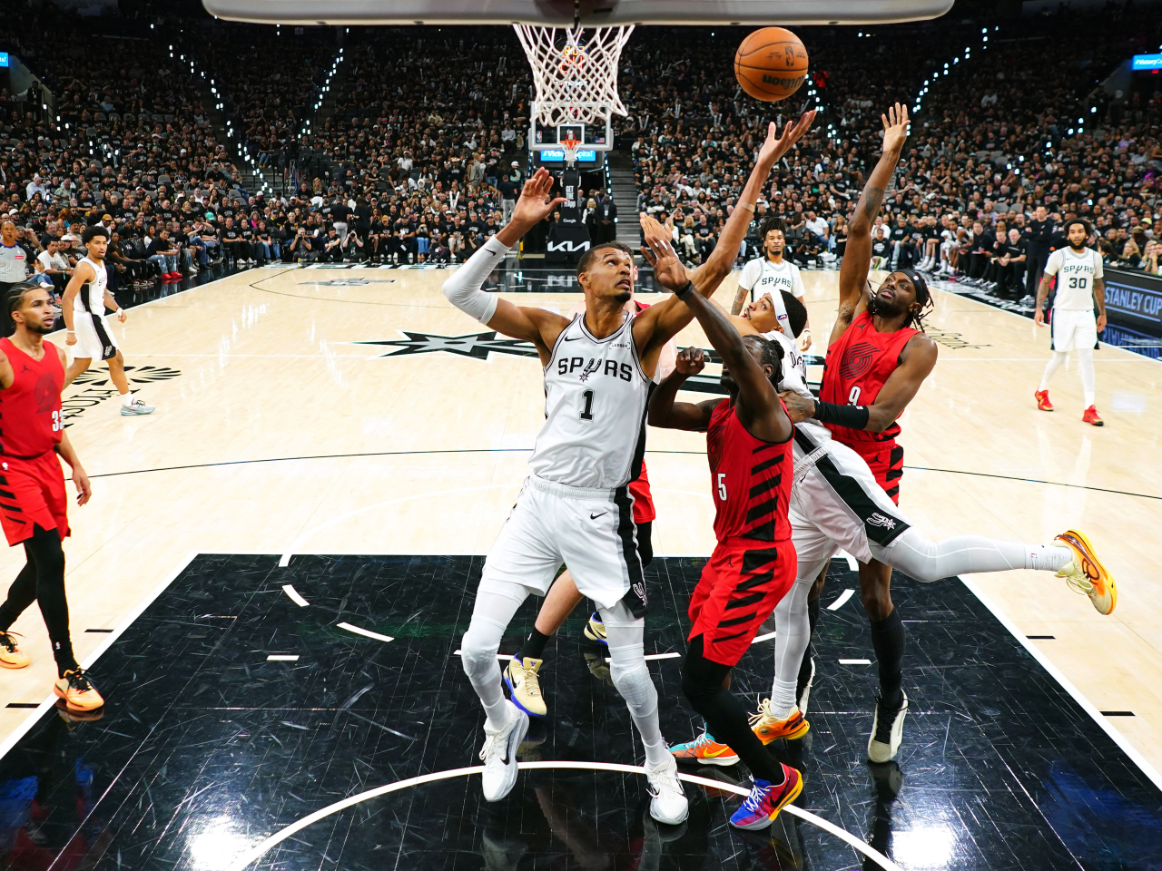 San Antonio Spurs forward Victor Wembanyama (1) reaches for a rebound over Portland Trail Blazers guard Jrue Holiday (5) and forward Jerami Grant (9). Photo: Reuters