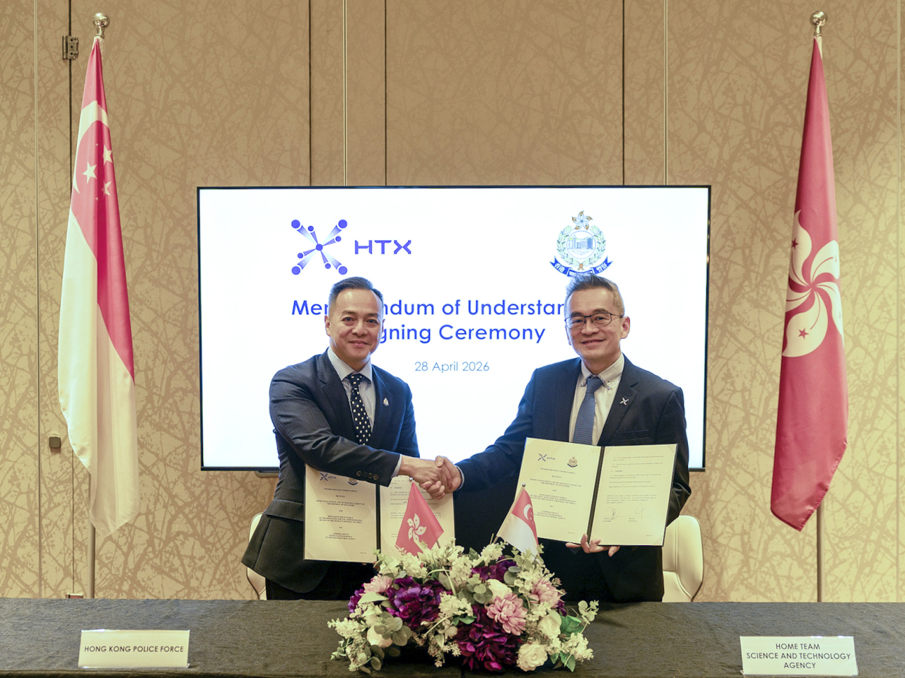 周一鳴（左）率領警隊代表團到訪新加坡，並與新加坡內政科技局局長曾燦簽署諒解備忘錄。（政府新聞處）
