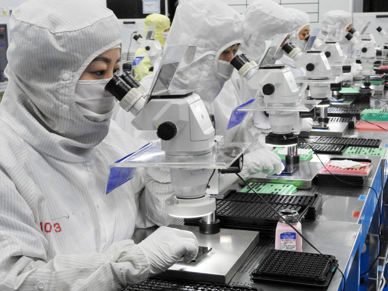Employees work on a production line for mobile phone camera lenses in Lianyungang, Jiangsu. Photo: Reuters