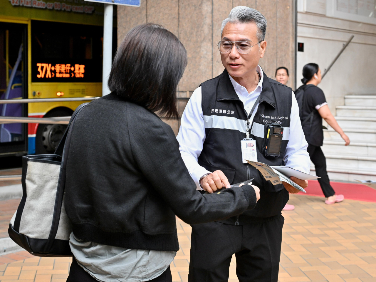 衞生署控煙酒辦公室人員今日於金鐘向市民及旅客宣傳有關禁令。（政府新聞處）