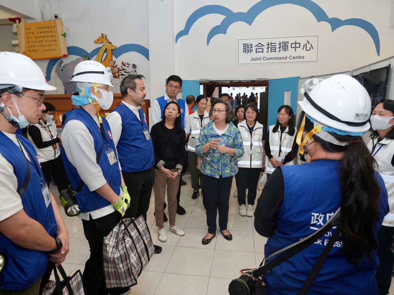 楊何蓓茵（中）下午與林雪麗（左四）在聯合指揮中心與公務員傾談，了解他們的工作情況。（楊何蓓茵社交網站）