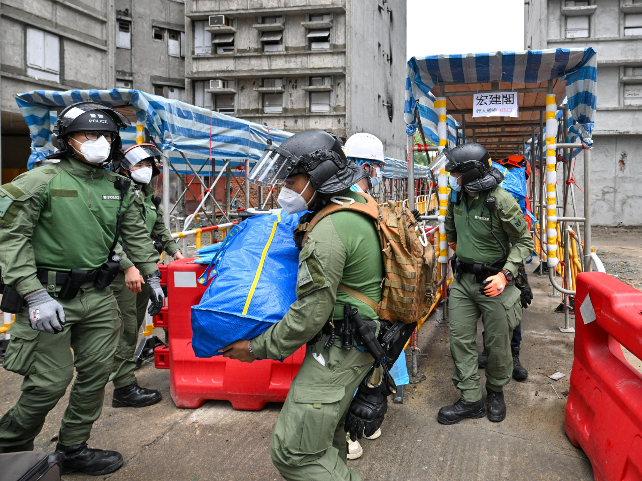 警員與民安隊隊員合力協助上樓居民搬走物品。(政府新聞處）