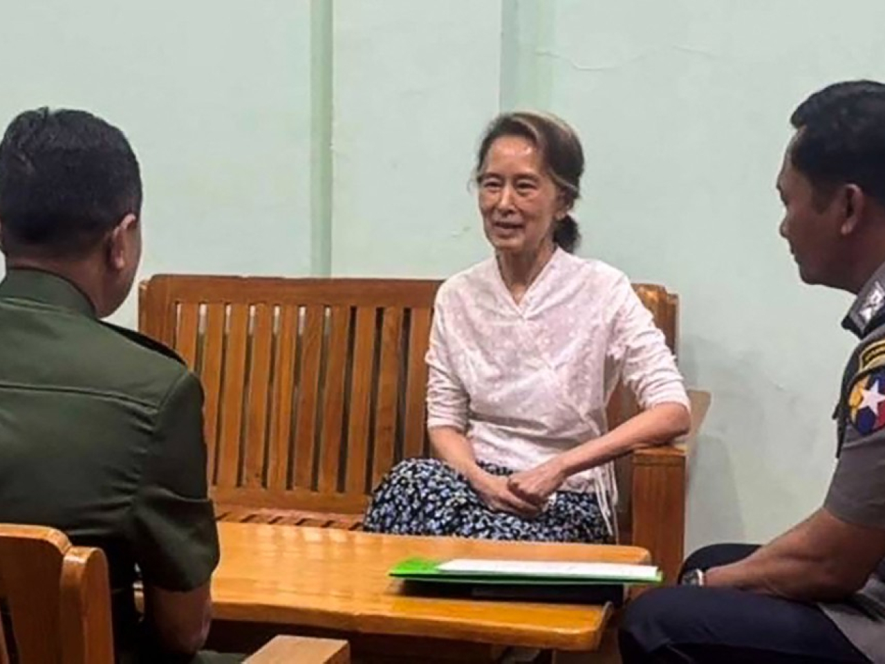 照片顯示80歲的昂山素姬與兩名身穿制服的人員聊天。（法新社）