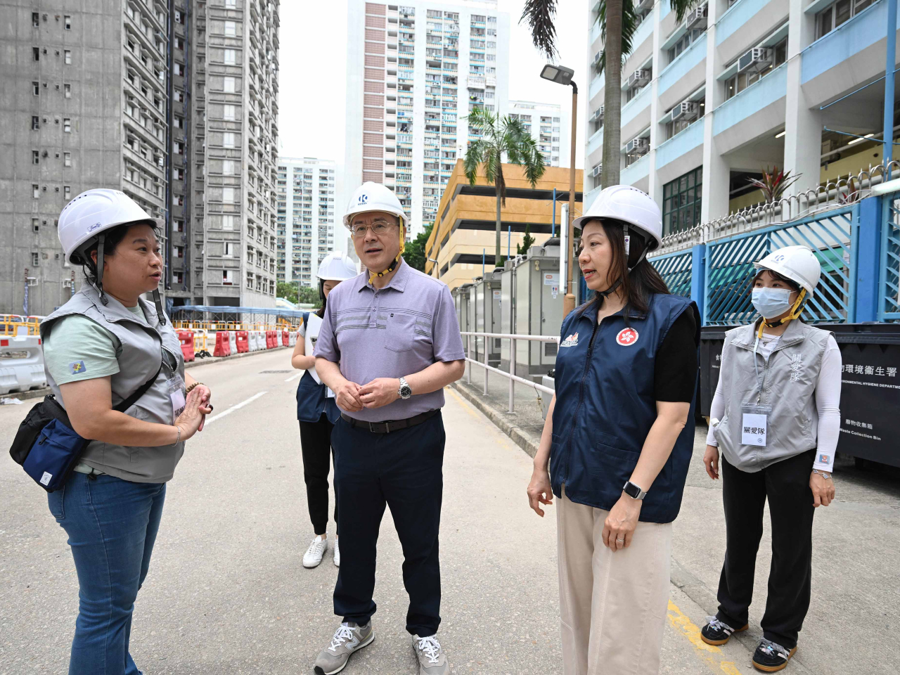 卓永興（左二）到大埔宏福苑視察上樓安排，並與地區服務及關愛隊伍義工交談。（政府新聞處）