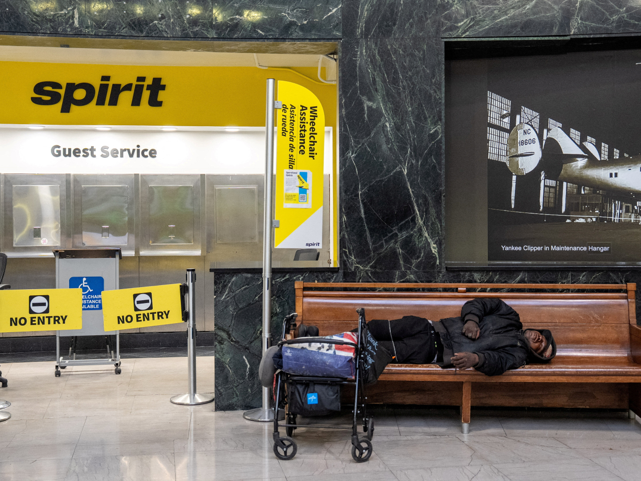 A person sleeps on a bench at the Spirit Airlines terminal at LaGuardia Airport in New York as the airline went bankrupt, ceasing operations. Photo: Reuters