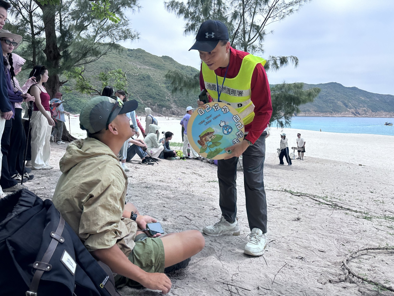 漁護署人員向遊客宣傳「自己垃圾自己帶走」 。（漁護署社交網站圖片）