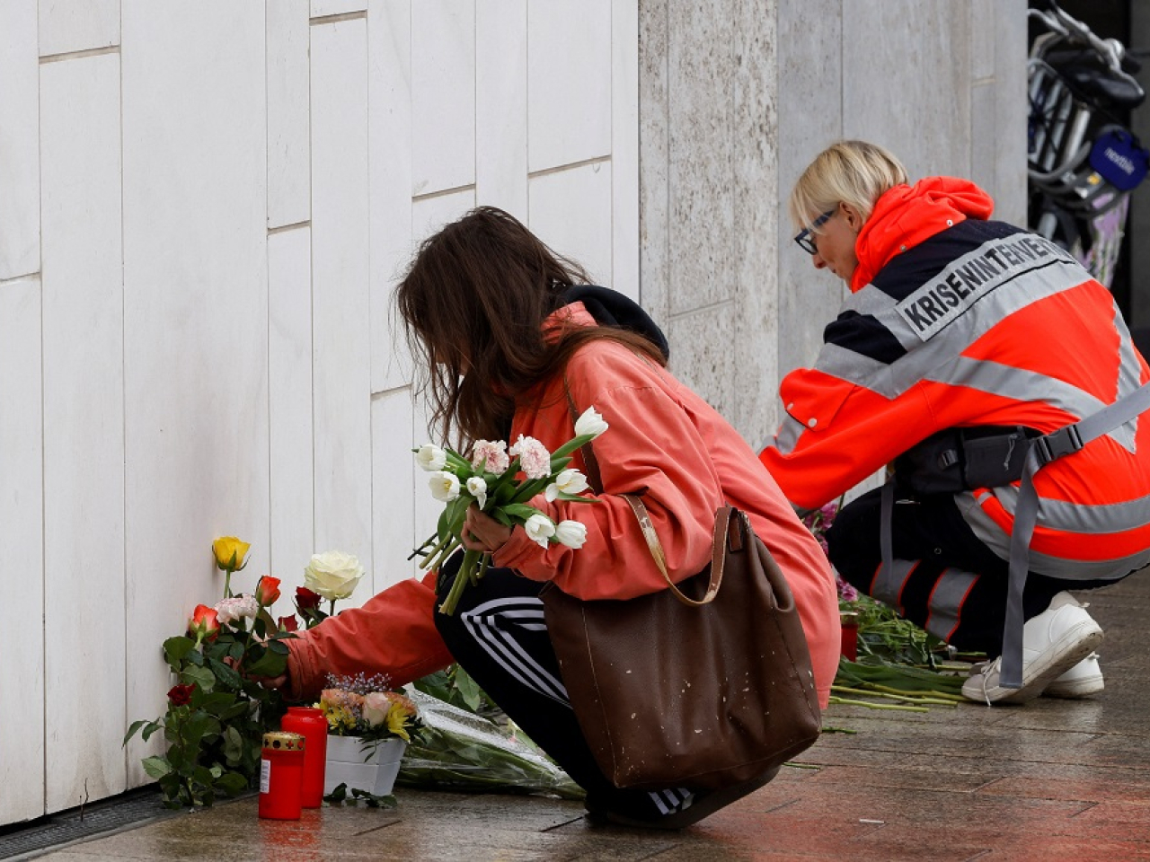 Women lay flowers near the site where two people died. Photo: Reuters