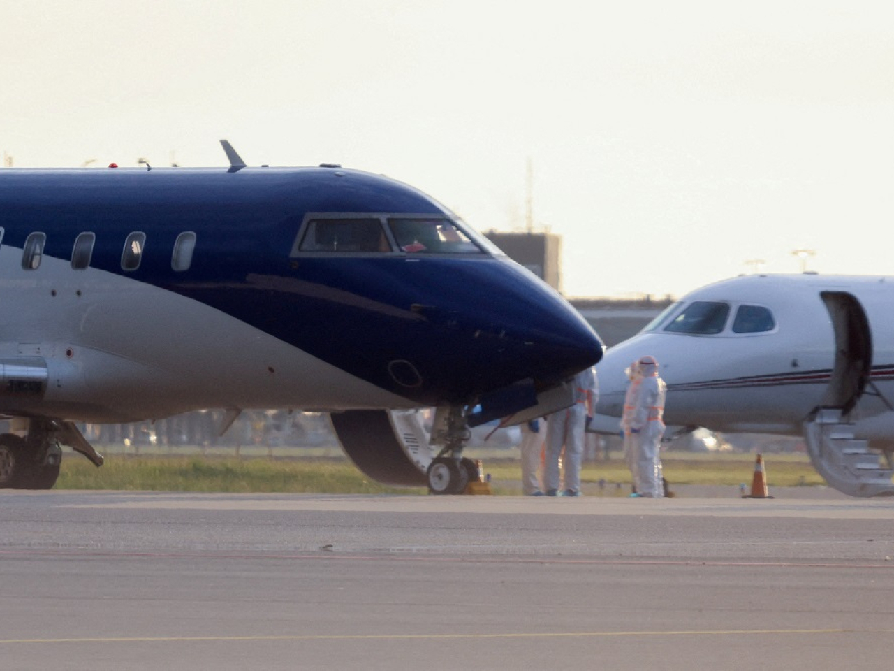 Health workers in hazmat suits stand next to an air ambulance as two hantavirus patients arrive at Schiphol Airport near Amsterdam. Photo: Reuters