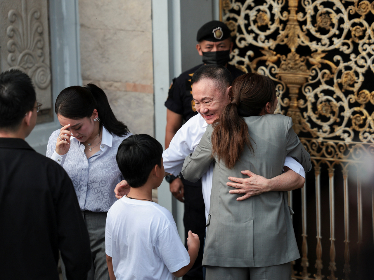 Thaksin Shinawatra hugs daughter Pintongtha Kunakornwong as Paetongtarn looks on after his release from prison in Bangkok. Photo: Reuters