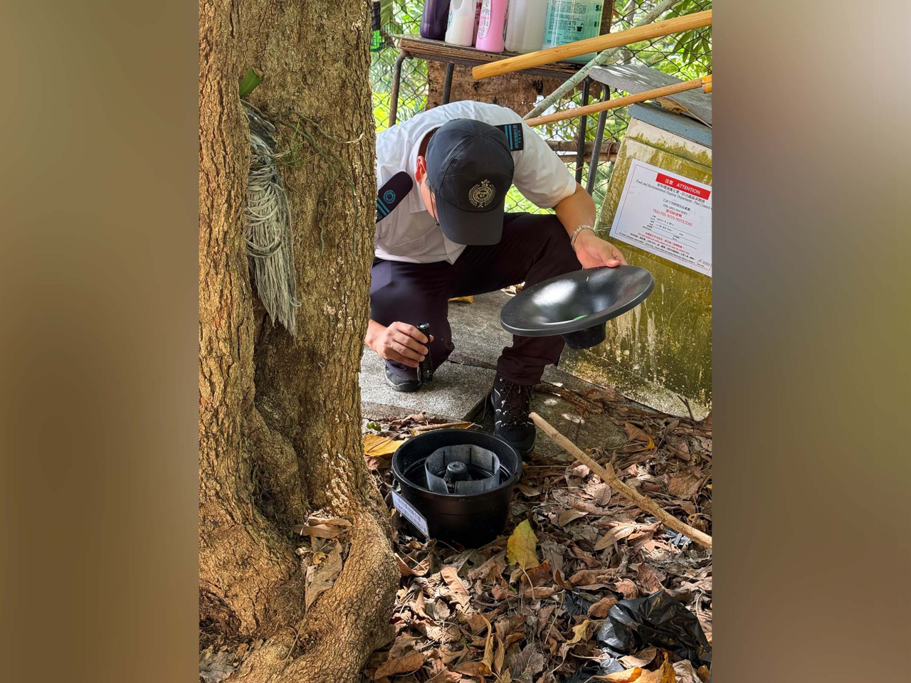 食環署人員巡視觀塘一間學校，檢查新型捕蚊器。（政府新聞處）