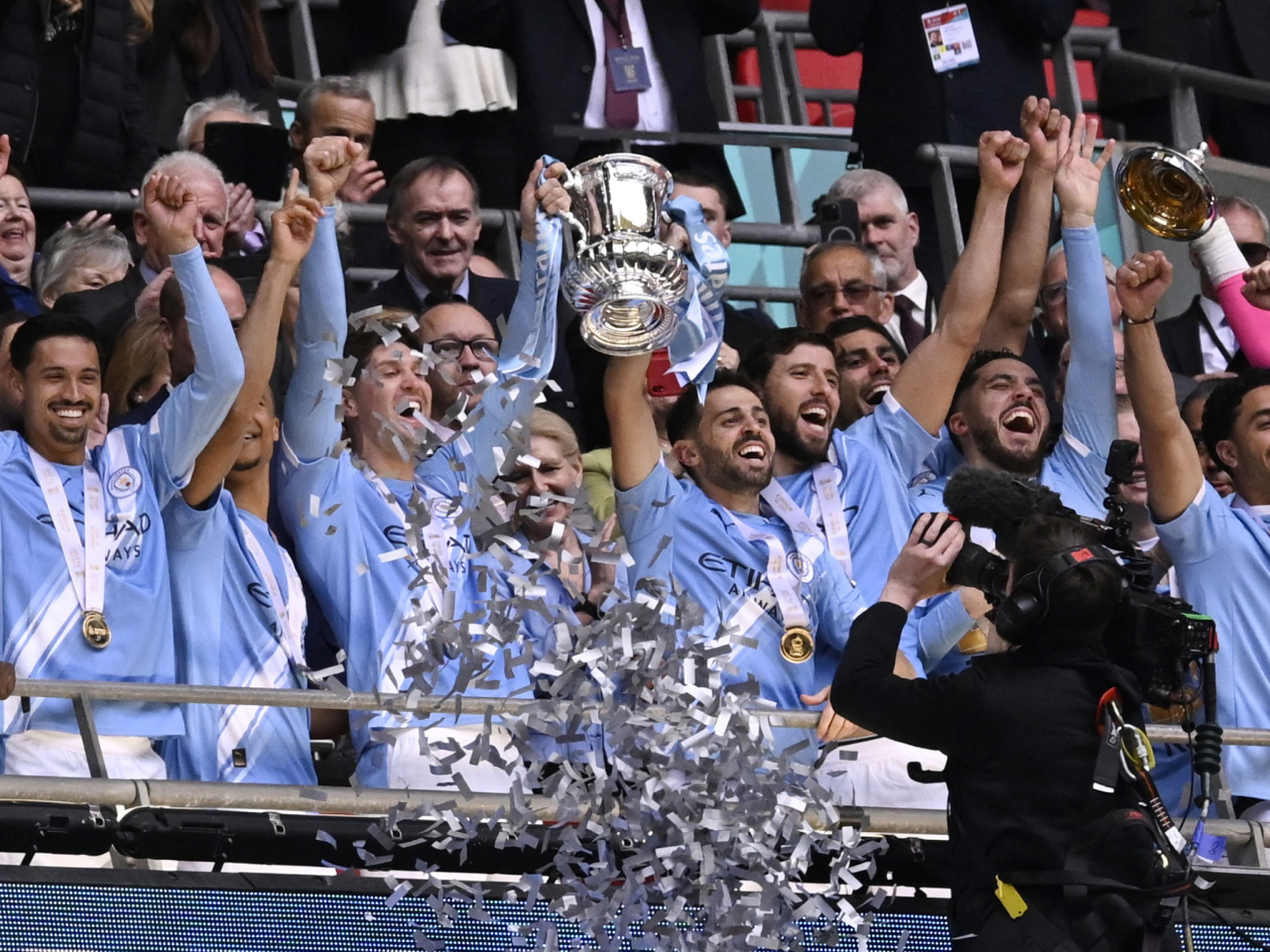 Manchester City's John Stones and Bernardo Silva celebrate lifting the FA Cup trophy with teammates. Photo: Reuters