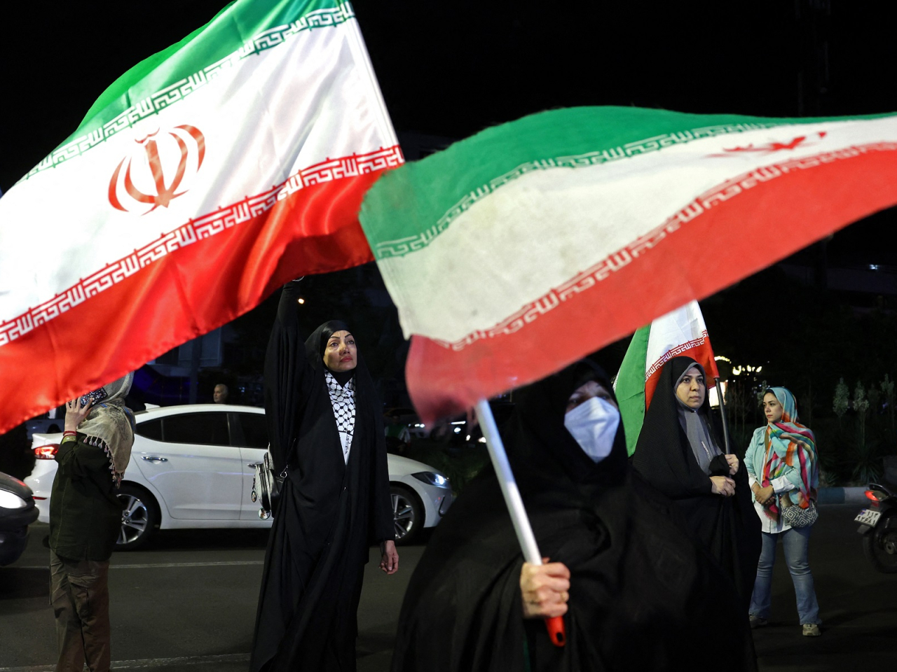 Women hold Iran's national flags during an anti-US and Israel protest at the Hafte Tir Square in Tehran. Photo: AFP