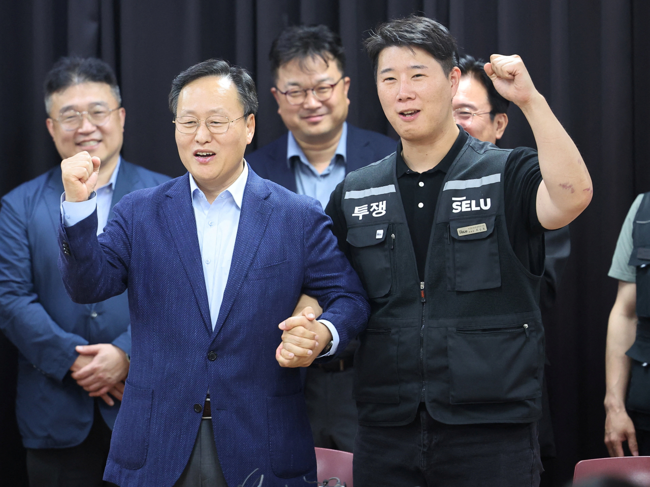 Chief management negotiator Yeo Myung-koo, left, and Samsung Electronics union chief Choi Seung-ho celebrate reaching the tentative deal. Photo: Reuters