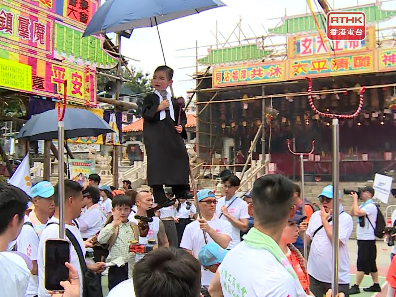 有飄色以電視劇集內容為主題，色芯演員模彷劇集角色，戴上眼鏡、身穿法官袍和手持法槌道具。（張連登攝）