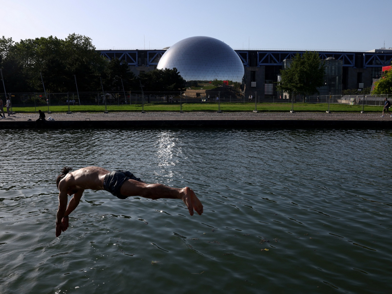 A man dives into the Canal de l'Ourcq to seek respite from the heat as temperatures soared above 30 degrees Celsius in Paris. Photo: Reuters