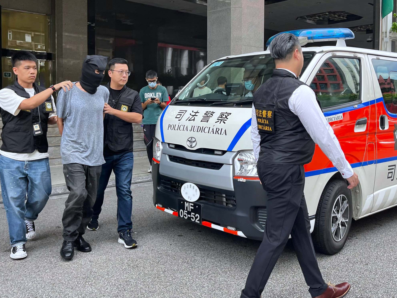 澳門司警將涉嫌強姦的64歲香港男司機押到檢察院偵訊。（鄭月明攝）