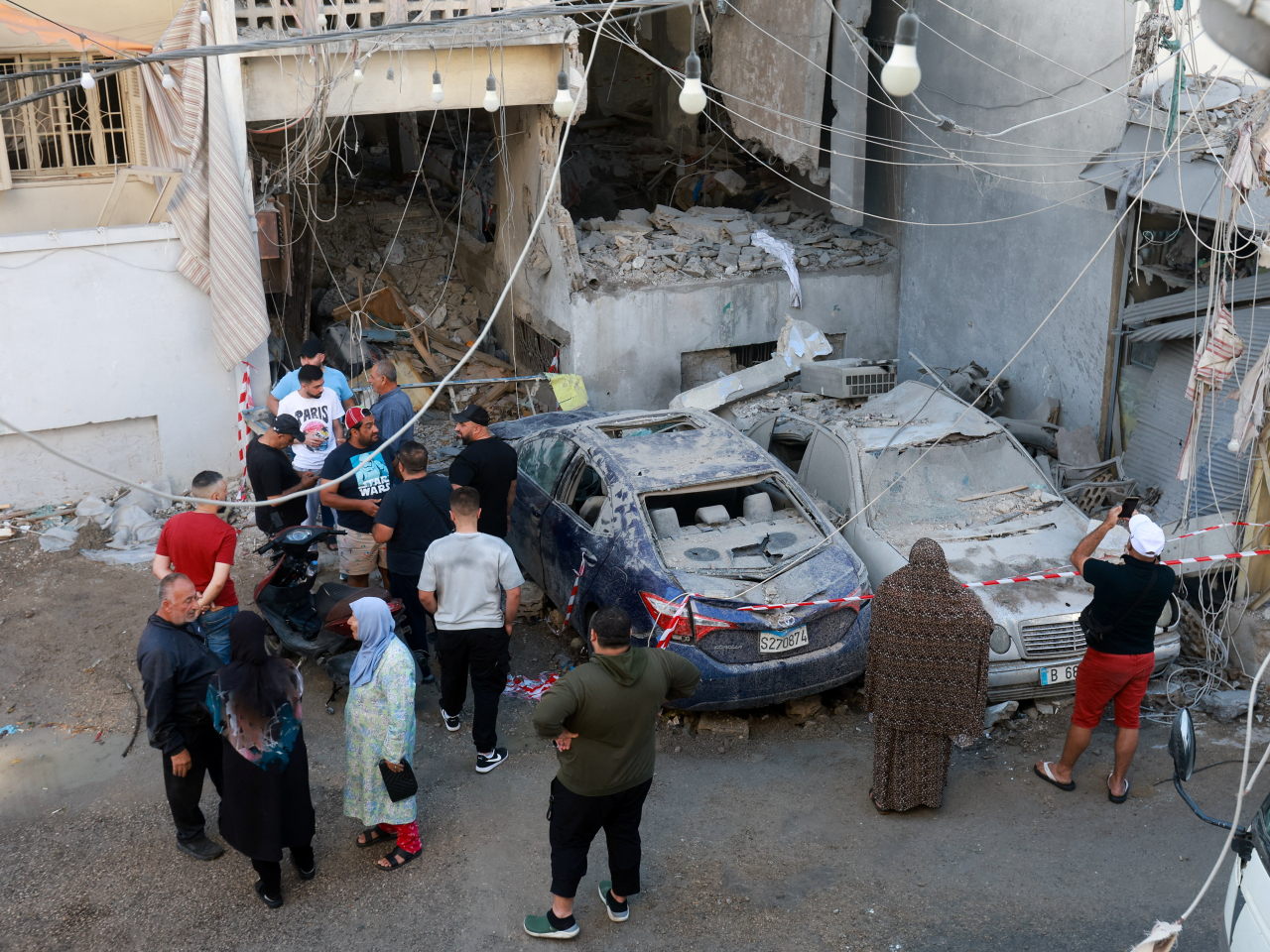 Lebanese in Sidon gather to assess the damage to their neighbourhood after an Israeli air strike. Photo: Reuters