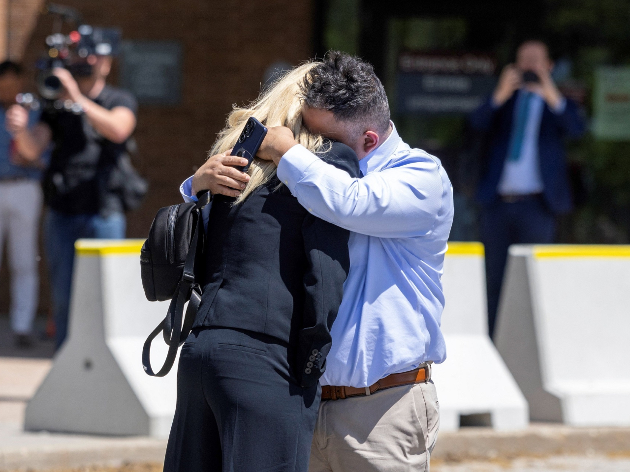 Leonardo Bedoya embraces his wife Maria Lopez as they remember their daughter Jeshennia, a victim of Kenneth Law outside court in Ontario. Photo: Reuters