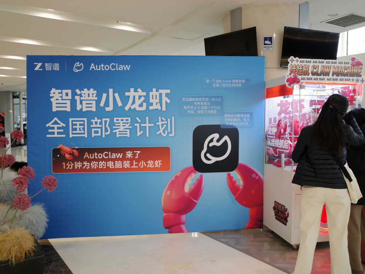 A claw machine filled with plush toys draws interest in Beijing during a setup session for AutoClaw, a local version of the AI agent OpenClaw developed by Zhipu. File photo: Reuters
