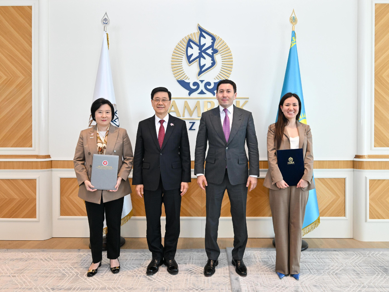 李家超與哈薩克國家主權財富基金Samruk Kazyna行政總裁Nurlan Zhakupov（右二）會面，兩人並見證投資推廣署與Samruk-Kazyna交換合作備忘錄。（政府新聞處）