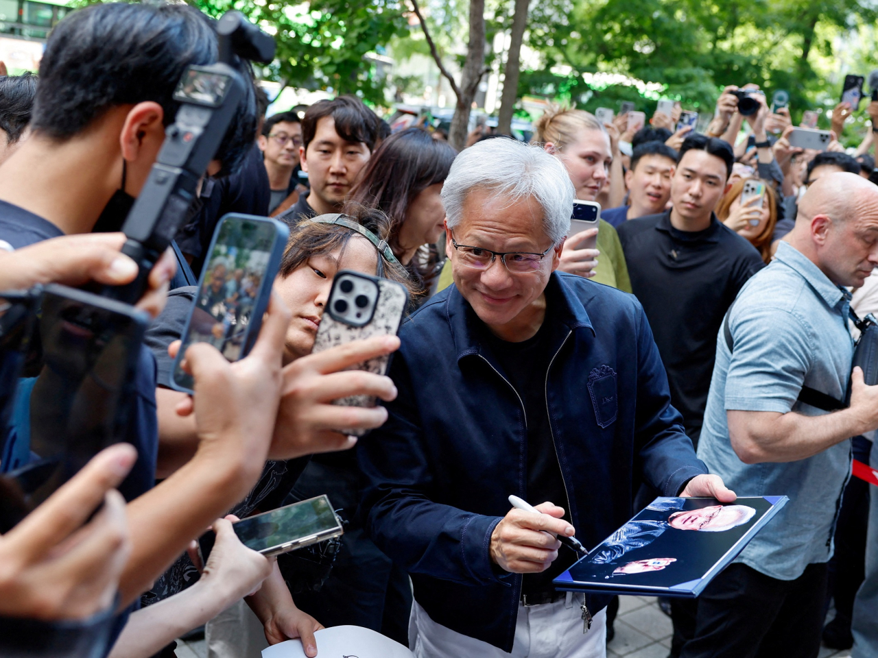 Jensen Huang takes a selfie with a fan in front of a PC cafe in Seoul. Photo: Reuters
