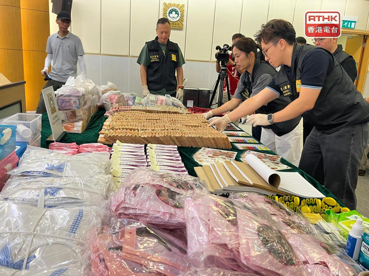 司警展示在行動中搜獲的涉案現金及折合約值5千萬澳門元的證物。(鄭月明攝)