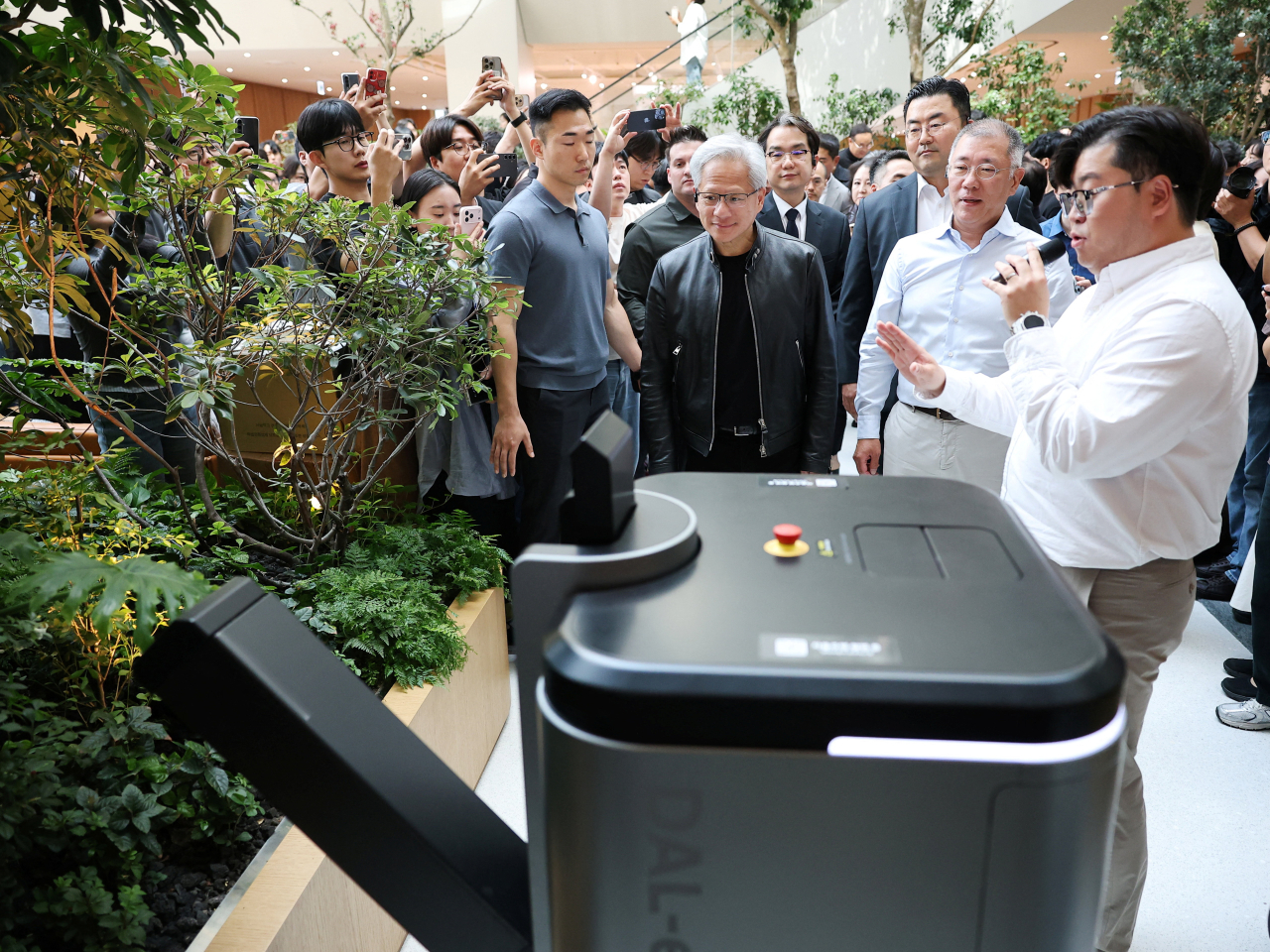 Jensen Huang, left, and Chung Eui-sun are briefed on a precision landscaping robot at Hyundai Motor's office in Seoul. Photo: Reuters
