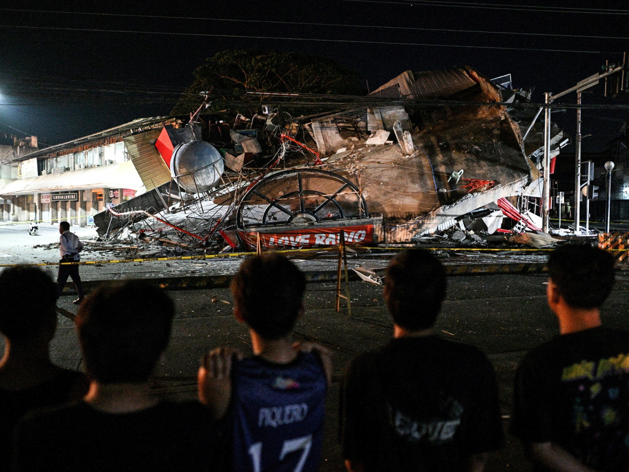 People look at a collapsed building following the magnitude 7.8 quake in General Santos, southern Philippines. Photo: Reuters