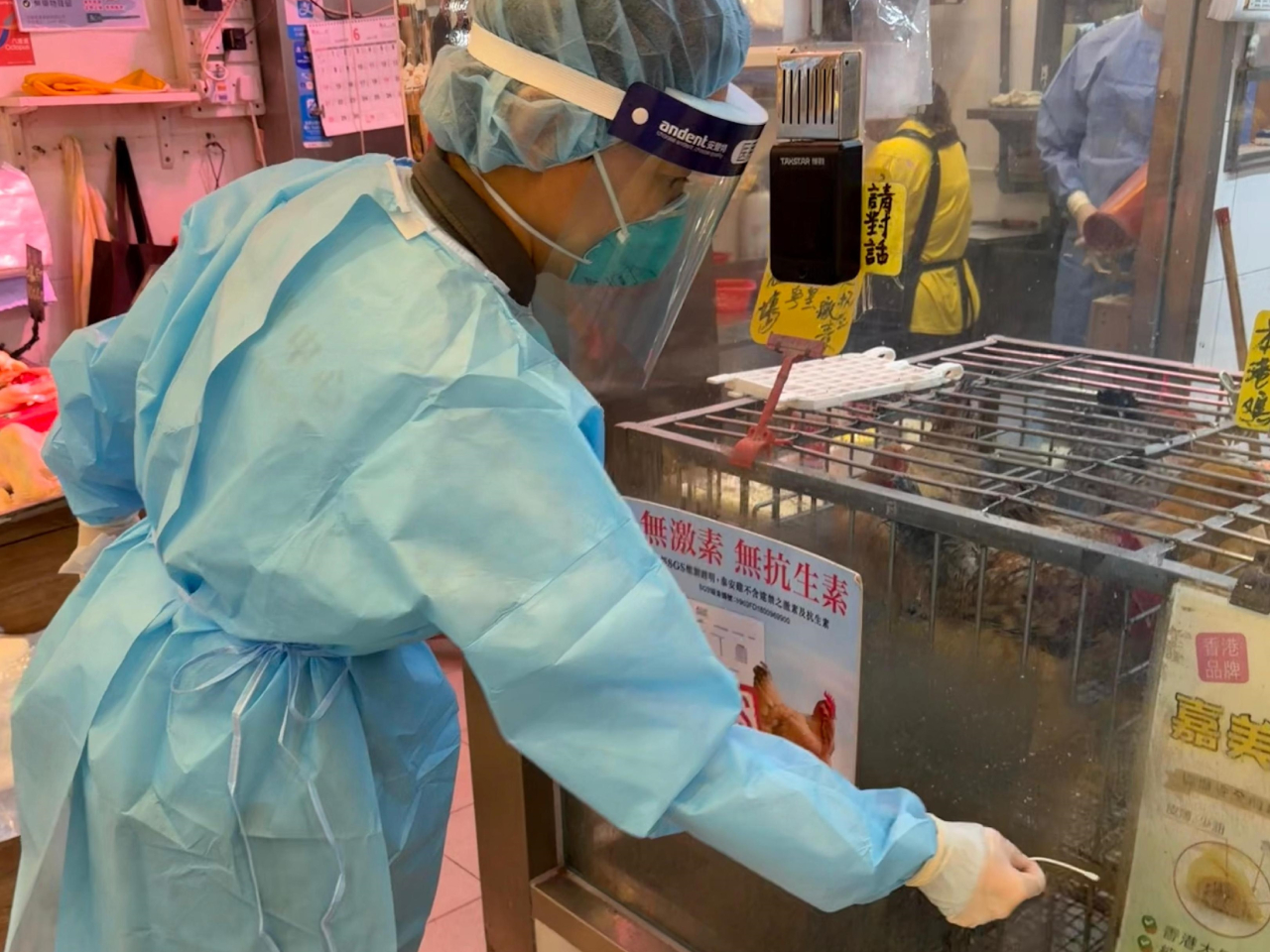 衞生防護中心人員在病人曾到過的新鮮糧食店採集環境樣本。（政府新聞處）