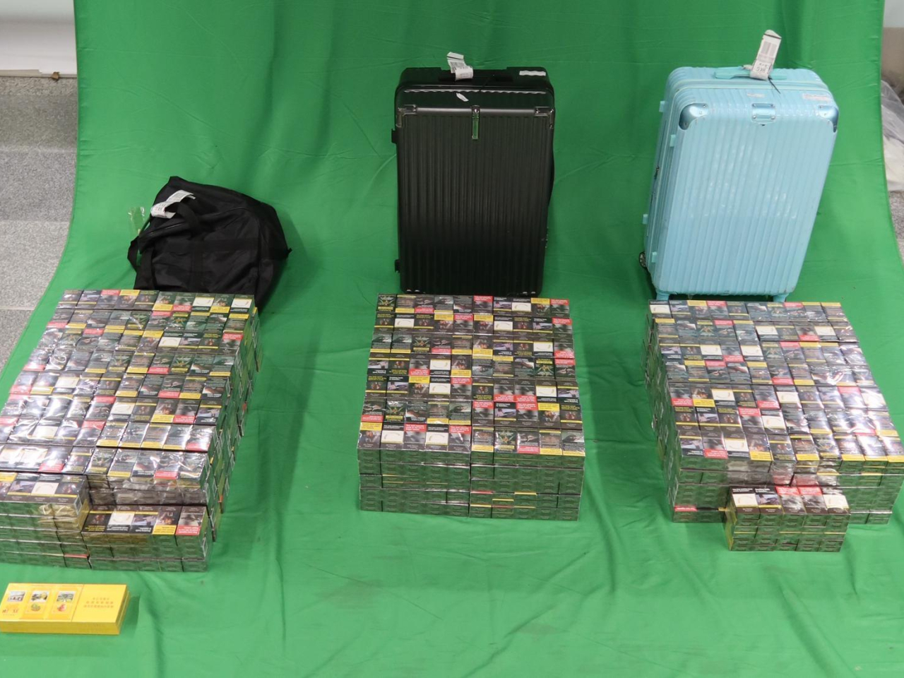 海關在兩名被捕旅客的個人行李內檢獲未完稅香煙。（政府新聞處提供）